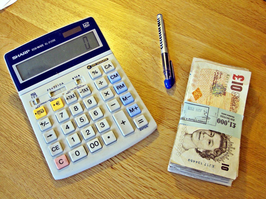 A calculator with money, illustrating what non-owner car insurance really costs